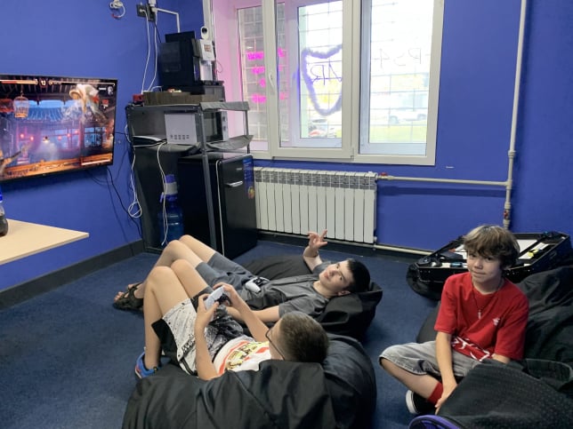 Діти їдять їжу у клубі віртуальної реальності. В цій кімнаті є Playstation та настільні ігри. Харків віртуальна реальність 2023 жовтень.